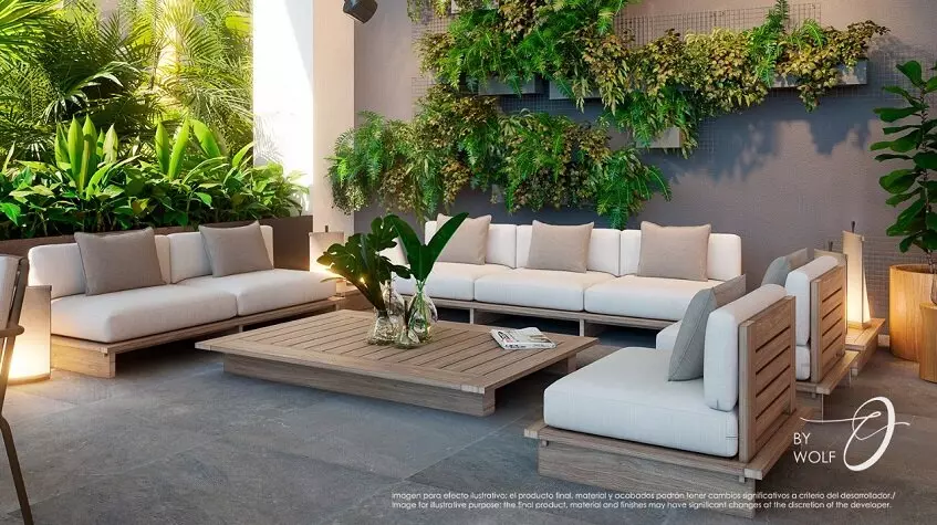 White sofas around a large coffee table, outdoor vegetation at Origin by Wolf Cancun
