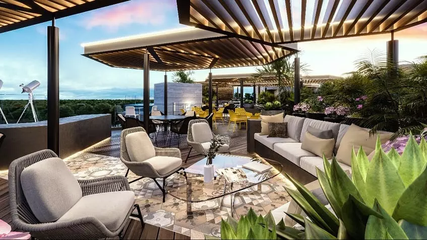 Lounge and dining area under pergolas, surrounded by vegetation at Kolmena Playa del Carmen