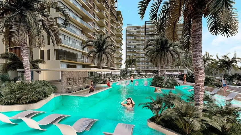 Pool, bar and people in the water, residential building facade with balconies at Valle Aurora Cancun