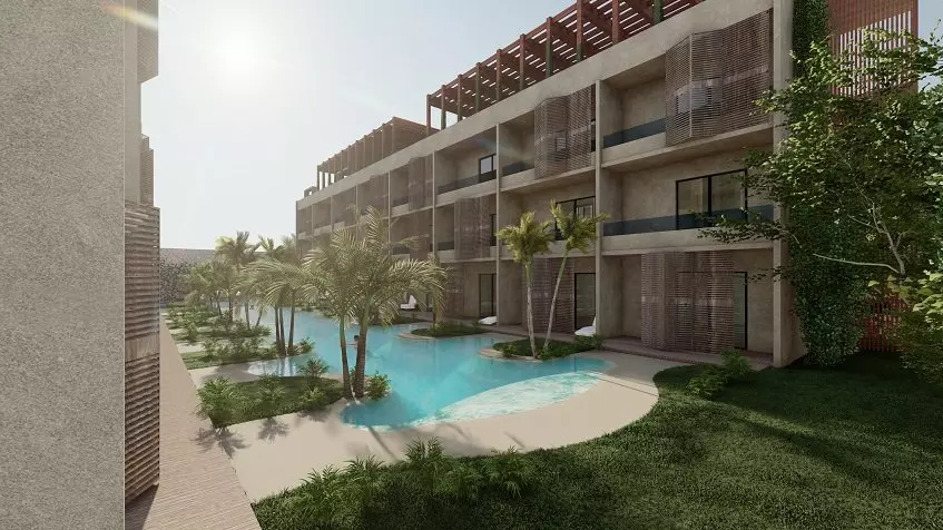 Residential Building facade with balconies, pool surrounded by palm trees at Cocay Lofts Tulum