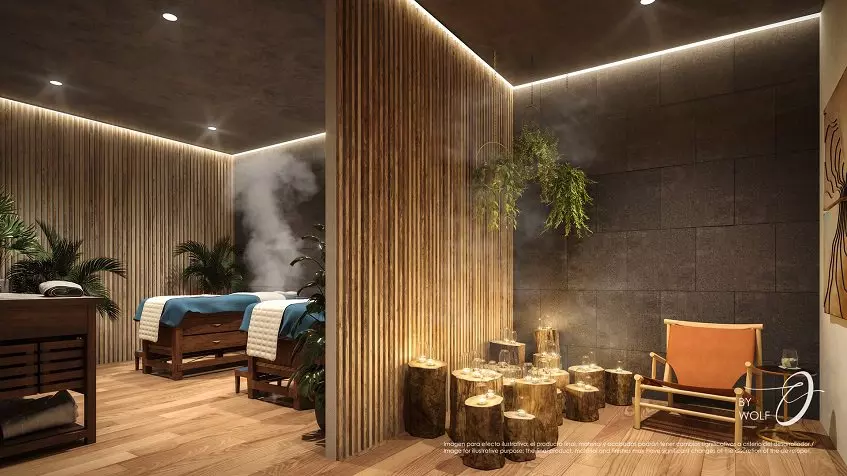 Few massage beds, half wooden wall, folding chair and a small table with glass of water at Origin by Wolf Cancun