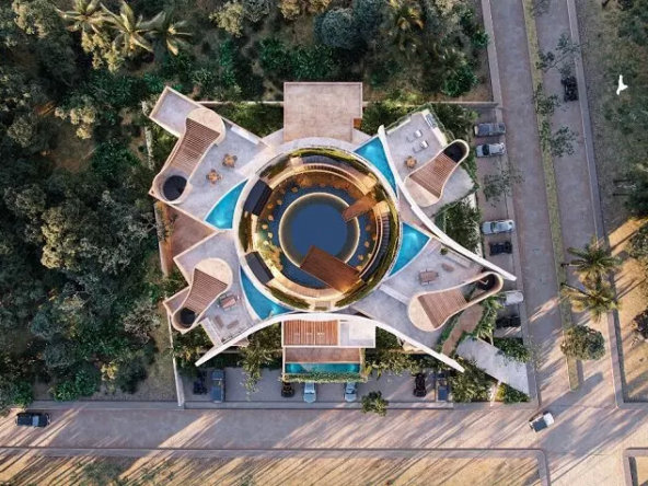 Aerial view of a round residential building by a jungle, round pool in the middle, rooftop terraces pools at Oniric Tulum