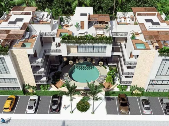 Aerial view of a residential building with a round pool and plunge pools on the rooftop at Xama Tulum