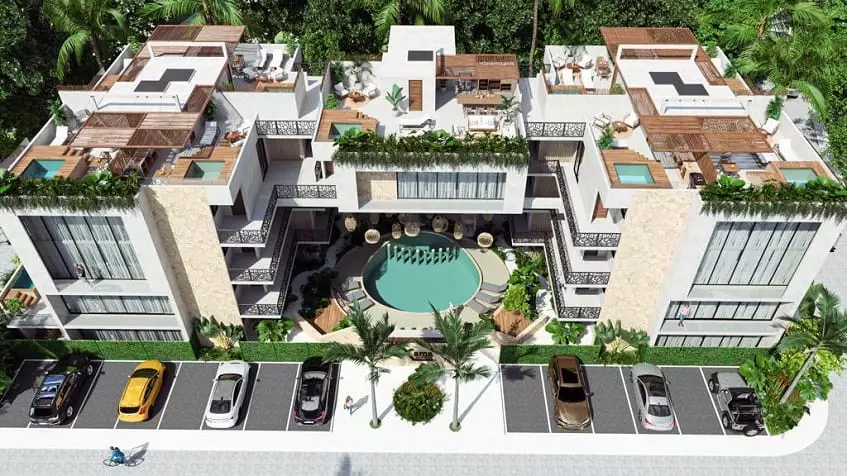 Aerial view of a residential building with a round pool and plunge pools on the rooftop at Xama Tulum