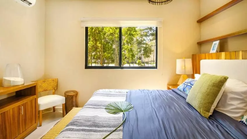Bedroom with a king size bed and small window at Selvanova Playa del Carmen