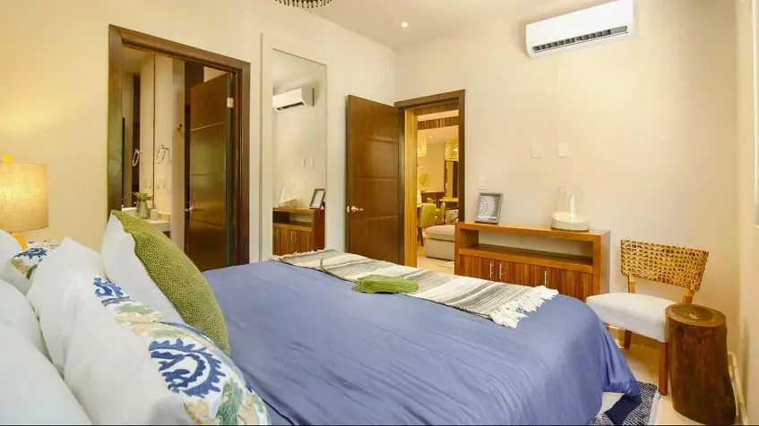 Master bedroom with a bathroom and a door open into a living room at Selvanova Playa del Carmen