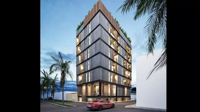 Residential building facade and a red car passing by at Torre 48 Playa del Carmen