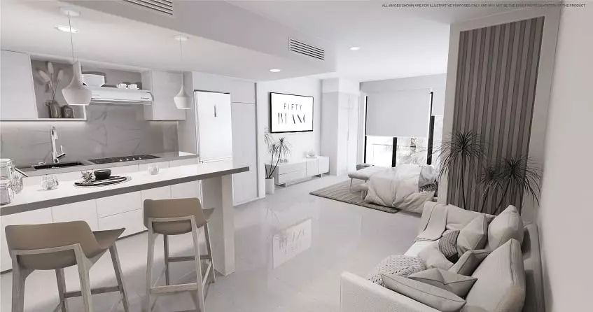 White kitchen with small breakfast bar, sofa, bed at Fifty Blanc Playa del Carmen