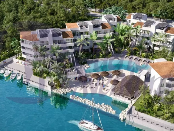 Residential building complex with a pool by a canal at Bloom Puerto Aventura