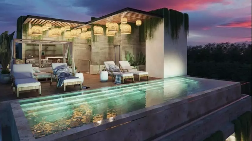 Rooftop pool and sunbeds during a sunset, pergola behind at Spirit Condos 1904