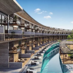 Residential building facade and large pool in a form of river at Awa Corasol