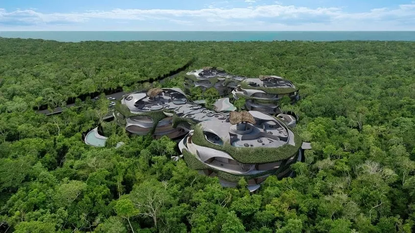 Aerial view of 4 round building with rooftop palapas in the jungle at Azulik Residences Tulum