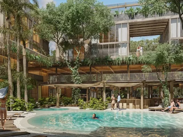 Residential building with balconies and a pool surrounded by trees, people around at Miraval Tulum