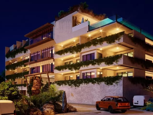 An exterior facade of a building at night with cars parked outside in Hunab Ku Tulum