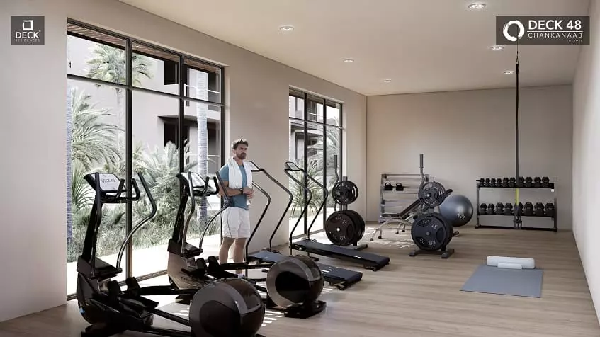 A gym with treadmills and a man standing on Deck 48 Cozumel