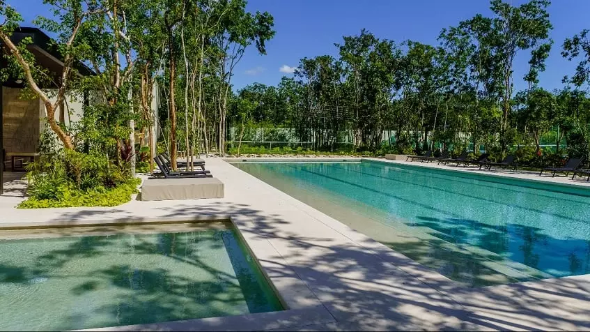 A semi-Olympic pool with trees around it in Villa Naranjo Playa del Carmen