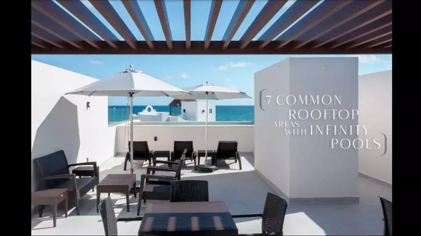 Rooftop terrace with an ocean view, tables, chairs and umbrellas at Santamar Prime Akumal