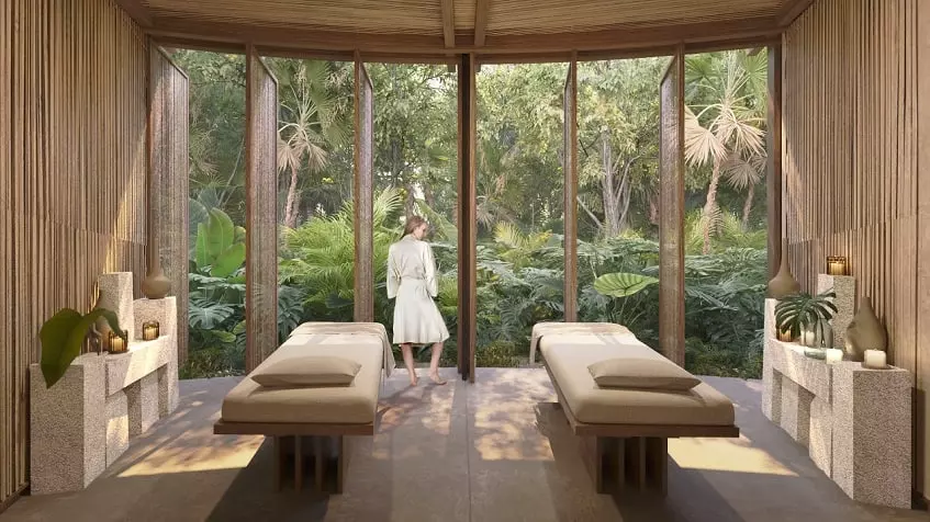 A woman standing in a spa and 2 massage beds in Aldea Mayab Bacalar