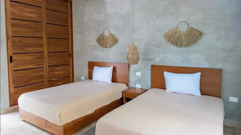 A bedroom with 2 beds and wooden closets in Villa Alquimia Tulum