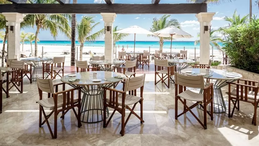 A restaurant with chairs and tables overlooking the sea at Vi-ha 36 Playacar