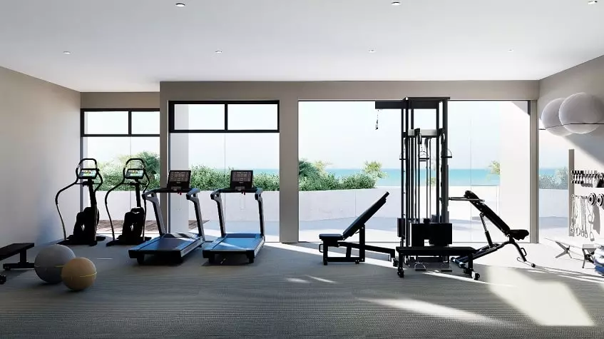 A gym with treadmills and ocean views at Sea Loft Cozumel