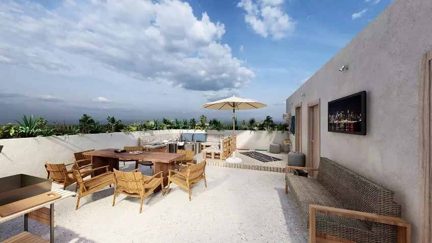 Rooftop with large dining table and grill area at Xkaa Downtown Condos