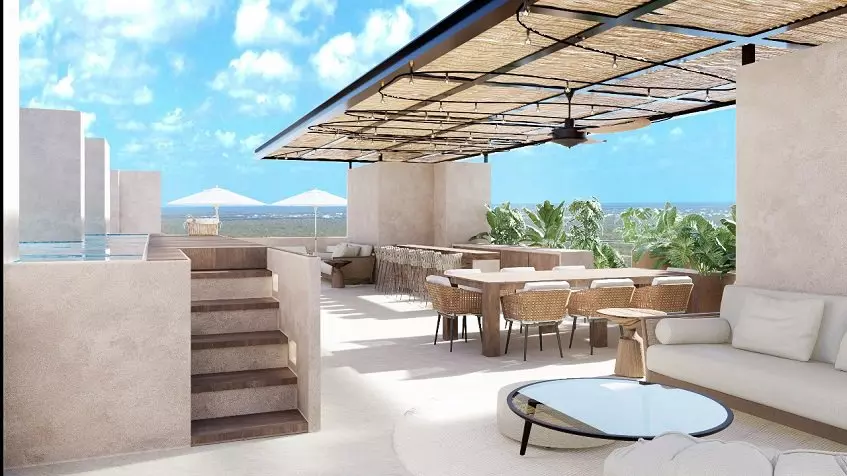 A terrace with umbrellas, lounge chairs, chairs and an ocean view at Sea loft Cozumel