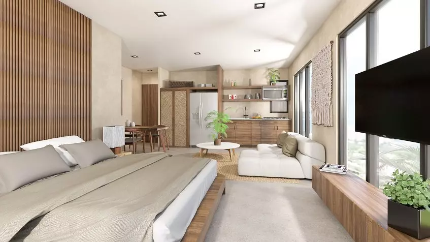 Apartment interior with a king size bed next to a dining table and kitchen and at Xkaa Downtown Condos