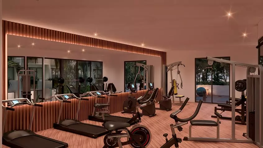 Gym with treadmills in front of a large mirror at Naj Origen Tulum
