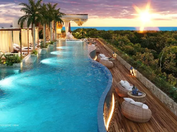 A large pool with sun loungers and lounge chairs at Nequen del Mar Tulum