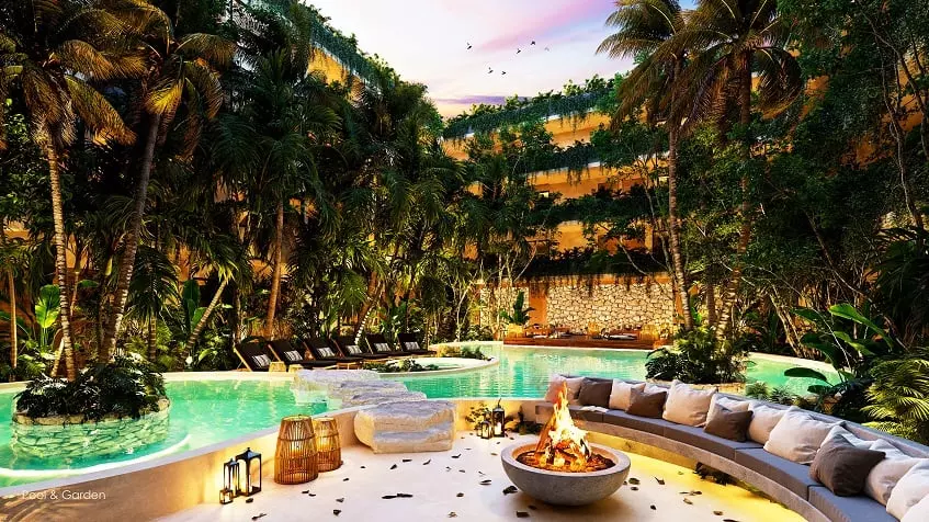 A pool with lounge chairs, a fire pit, and palm trees at Nequén del Mar Tulum