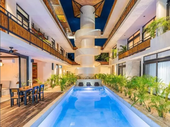 Ground floor pool, common area and spiral staircase at Irie Tulum