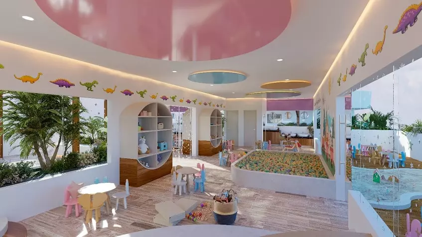 A playroom with toys, a ball pool and chairs with small tables at Mara Bella Cancun
