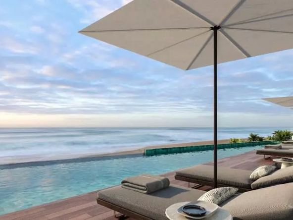 A terrace with a pool, some lounge chairs and umbrellas overlooking the sea at Playa 35