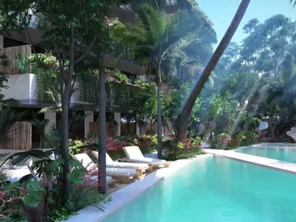 A pool area with lounge chairs and surrounding gardens at Natura Tulum