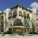 A facade of a corner apartment building with plants around it in Retrit