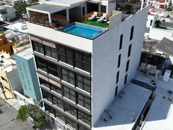 Aerial view of an apartment complex with a rooftop pool at Tower 25