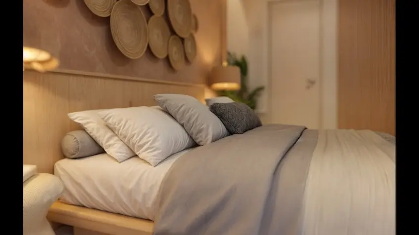 A bed with Pillows and a Lamp Macondo Punta Esmeralda Playa del Carmen
