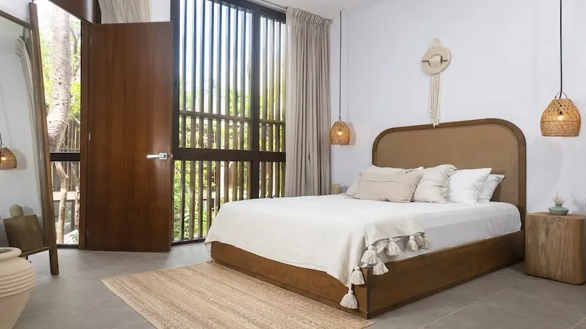 A bed in a room with a door in Isabella Tulum