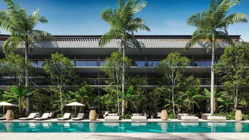 A swimming pool with lounge chairs and trees in front of a building in Legacy By Awa Playacar