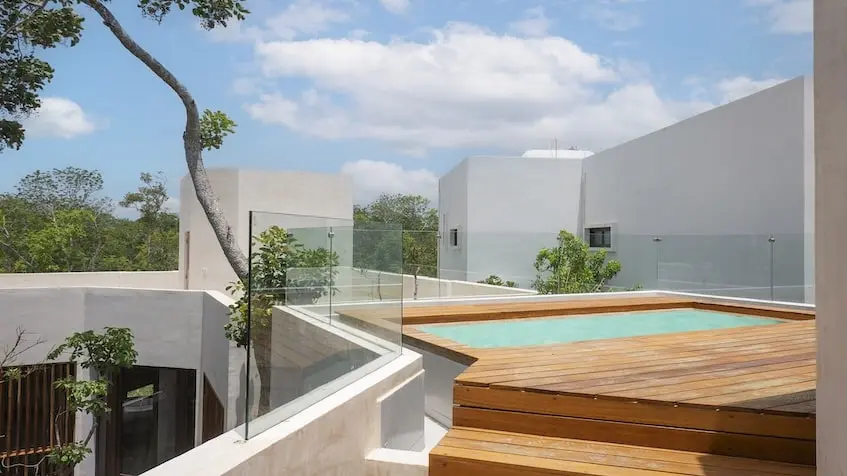 A deck with a pool and a glass fence in Isabella Tulum