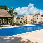 Piscina con edificio de palapa y áreas de condominio en Real Amalfi