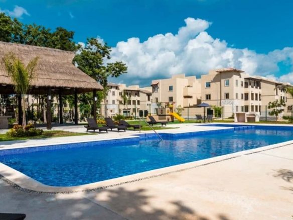 Piscina con edificio de palapa y áreas de condominio en Real Amalfi