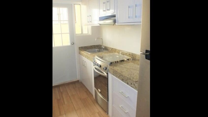 Cocina con media puerta de vidrio y patio en Portocristo Condos