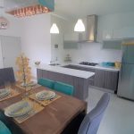Cuisine et salle à manger avec chaises grises et vertes à Palmyra Condos