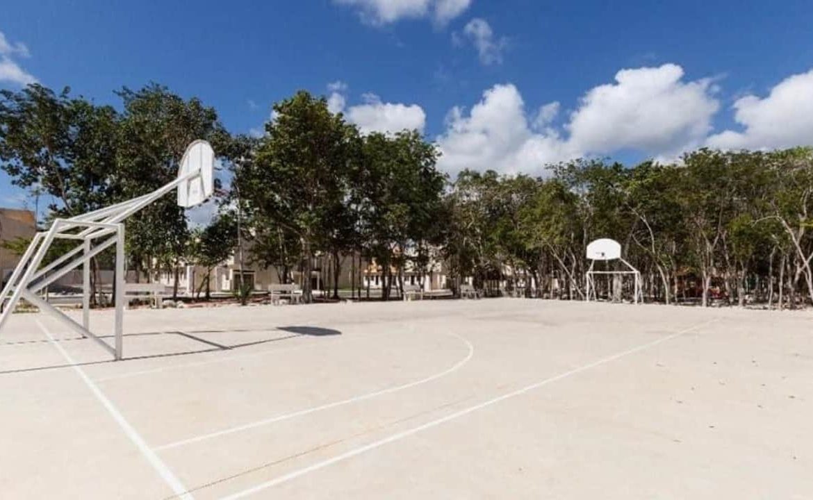 Cancha de fútbol y baloncesto rodeada de parque en Real Amalfi