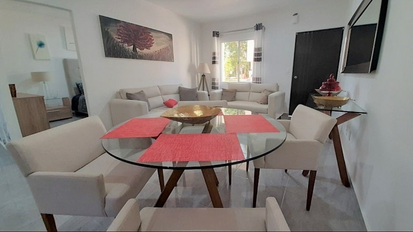 Salón con sofá blanco y mesa de comedor redonda en Burgos