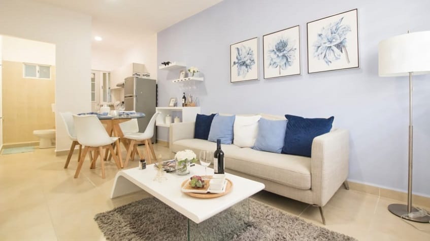 Sala de estar con botella de vino y una copa en una mesa de café junto al sofá en Portocristo Condos