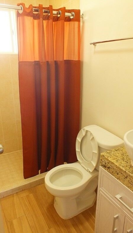 Baño con cortina de ducha roja en el Real Bilbao