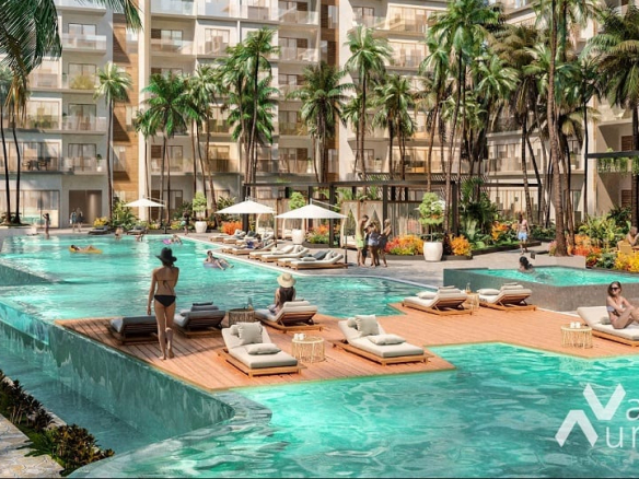 Large pool and sundeck surrounded by palm trees and people everywhere in Valle Aurora